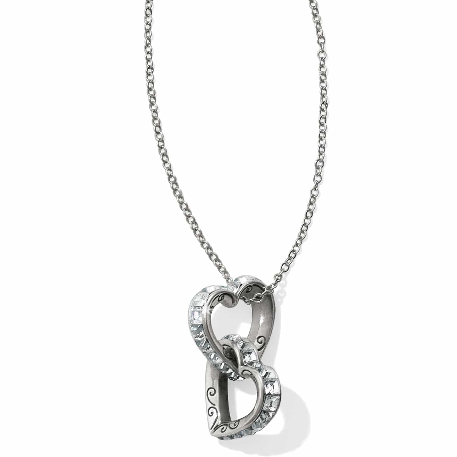 Brighton pendant necklace with two interlocking silver-plated hearts featuring crystal accents and scroll detail on a white background