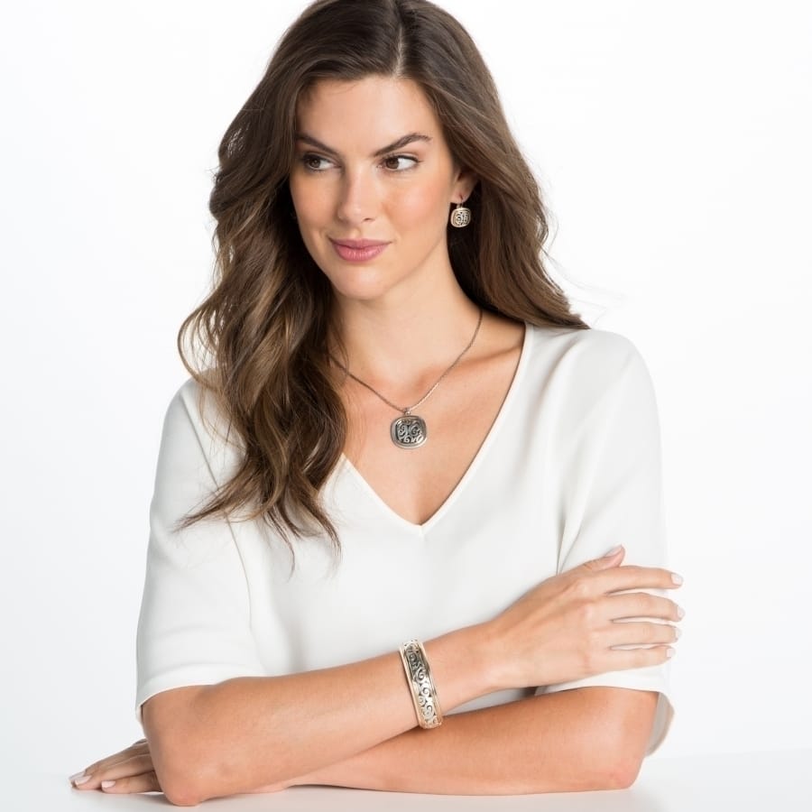 Model wearing a Brighton silver-plated pendant necklace with matching scroll-patterned earrings and coordinating Brighton accessories