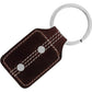 Brighton key fob with brown leather tag, white contrast stitching, silver-tone studs, and split ring on a white background