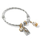 Brighton twisted silver-tone bangle bracelet with nativity charm, crystal charms, and gold Christmas tree on a white background