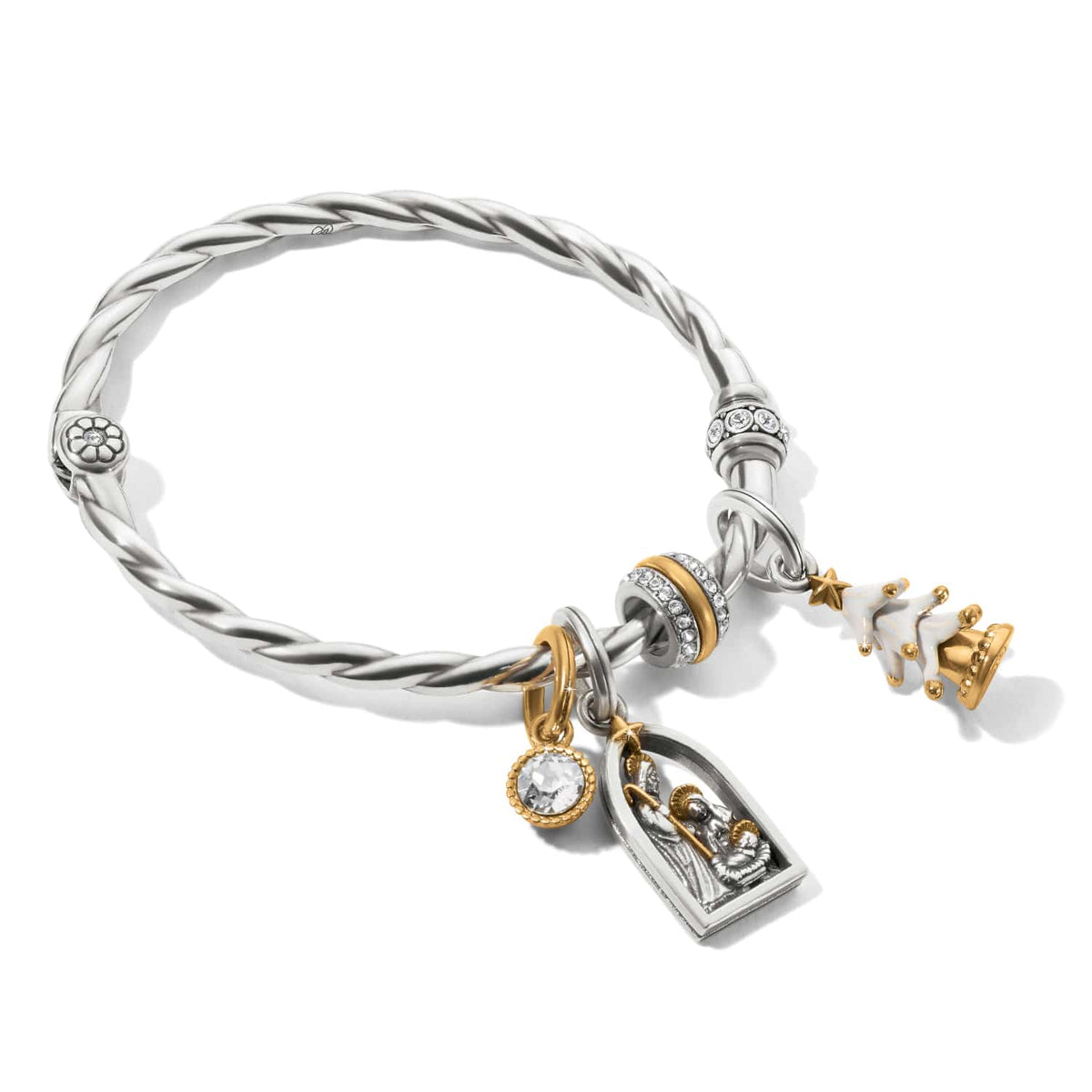 Brighton twisted silver-tone bangle bracelet with nativity charm, crystal charms, and gold Christmas tree on a white background