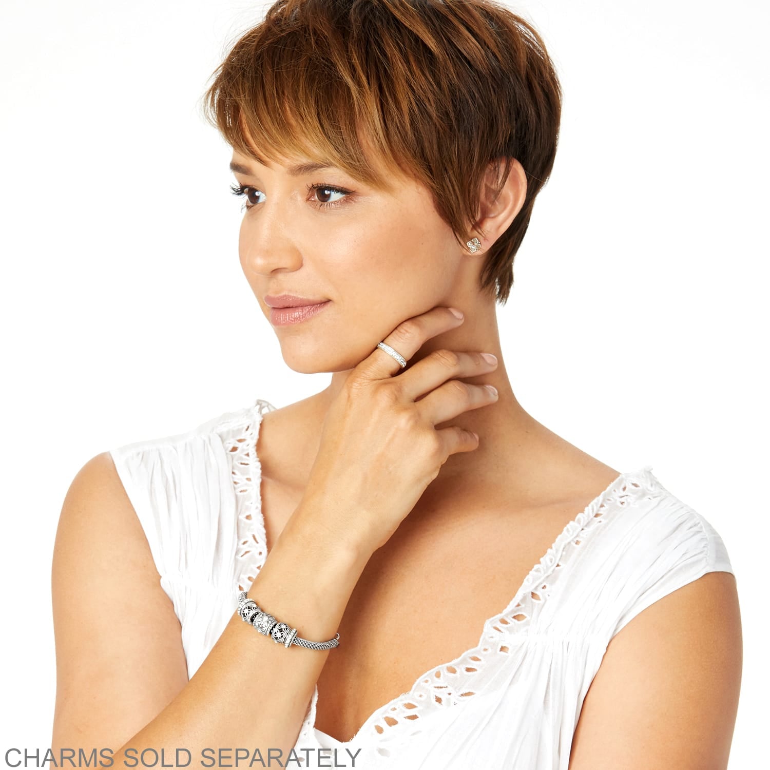 Model wearing a Brighton silver-plated charm bracelet with mesh band and coordinating Brighton accessories including ring and earrings