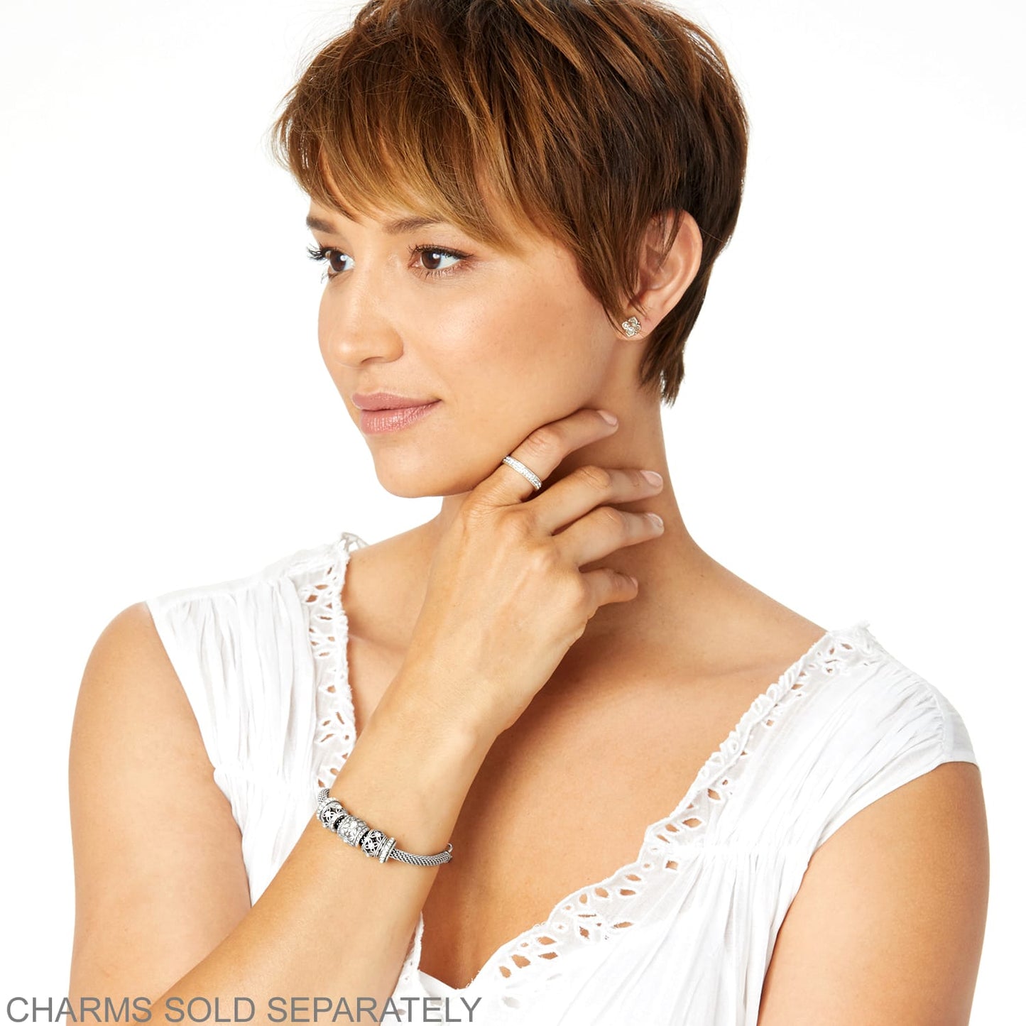 Model wearing a Brighton silver-plated charm bracelet with mesh band and coordinating Brighton accessories including ring and earrings