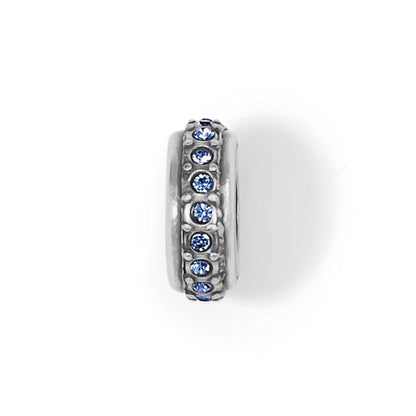 Brighton spacer charm with silver-plated finish and row of blue crystals around the band on a white background