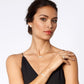 Model wearing a Brighton silver-plated cross necklace with coordinating Brighton accessories including bracelet, ring, and earrings