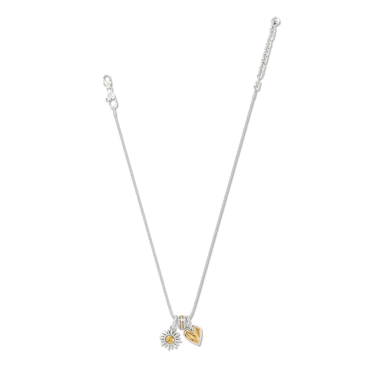 Brighton silver-plated charm necklace with crystal accent, silver sunflower charm, and gold heart charm on a white background