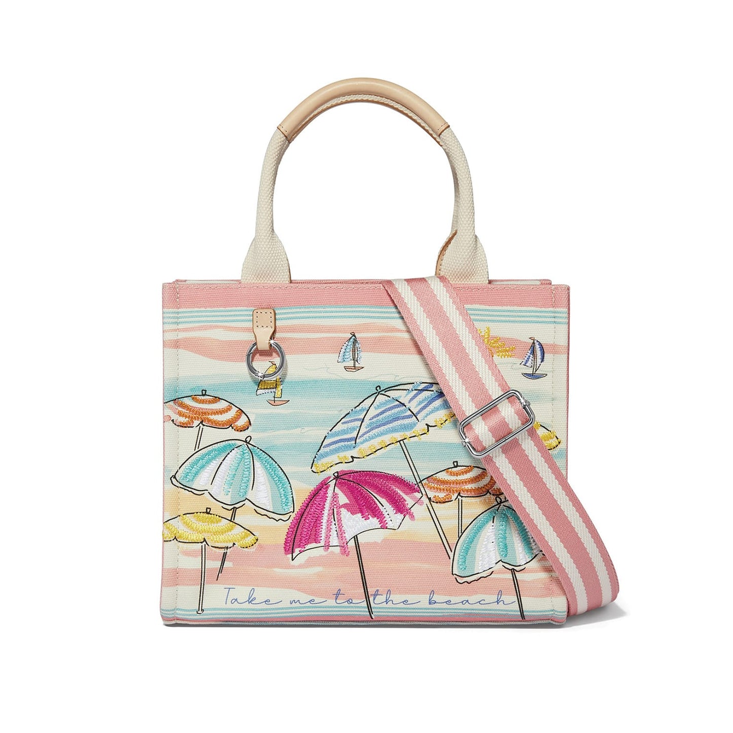 Brighton tote handbag with embroidered beach umbrella print, canvas handles, and pink striped crossbody strap on a white background