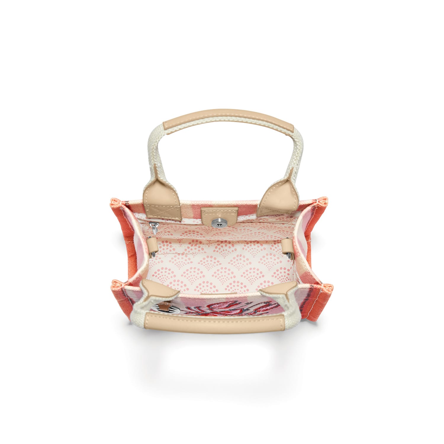 Brighton handbag interior view showing pink patterned lining, tan trim, woven handle, and magnetic closure on a white background