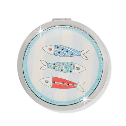 Brighton compact mirror with three illustrated fish in blue, teal, and red with silver-tone studs on a white background