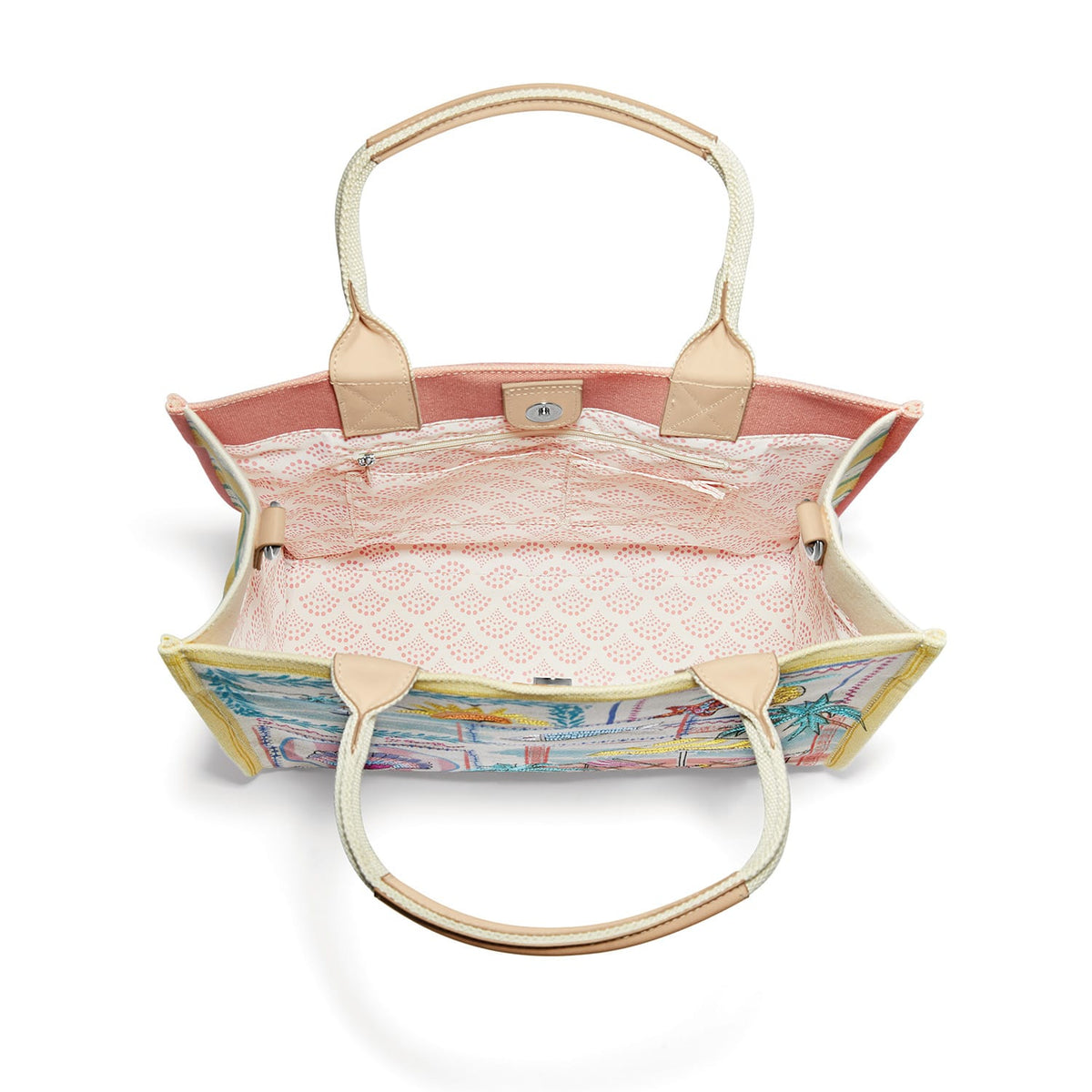 Brighton handbag interior view showing pink patterned lining, zip pocket, and canvas handles on a white background
