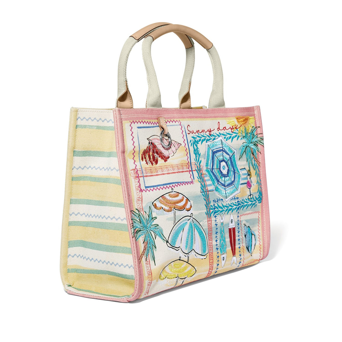 Brighton canvas tote handbag with embroidered beach umbrella print, striped side panels, and tan handles on a white background