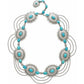 Brighton necklace with dyed turquoise howlite stones, silver-tone concho medallions, and draped chains on a white background