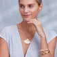 Model wearing a Brighton gold shell pendant necklace with coordinating Brighton beaded hoop earrings and bracelets