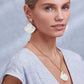 Model wearing Brighton gold-plated shell drop earrings paired with a matching shell pendant necklace on gold chain