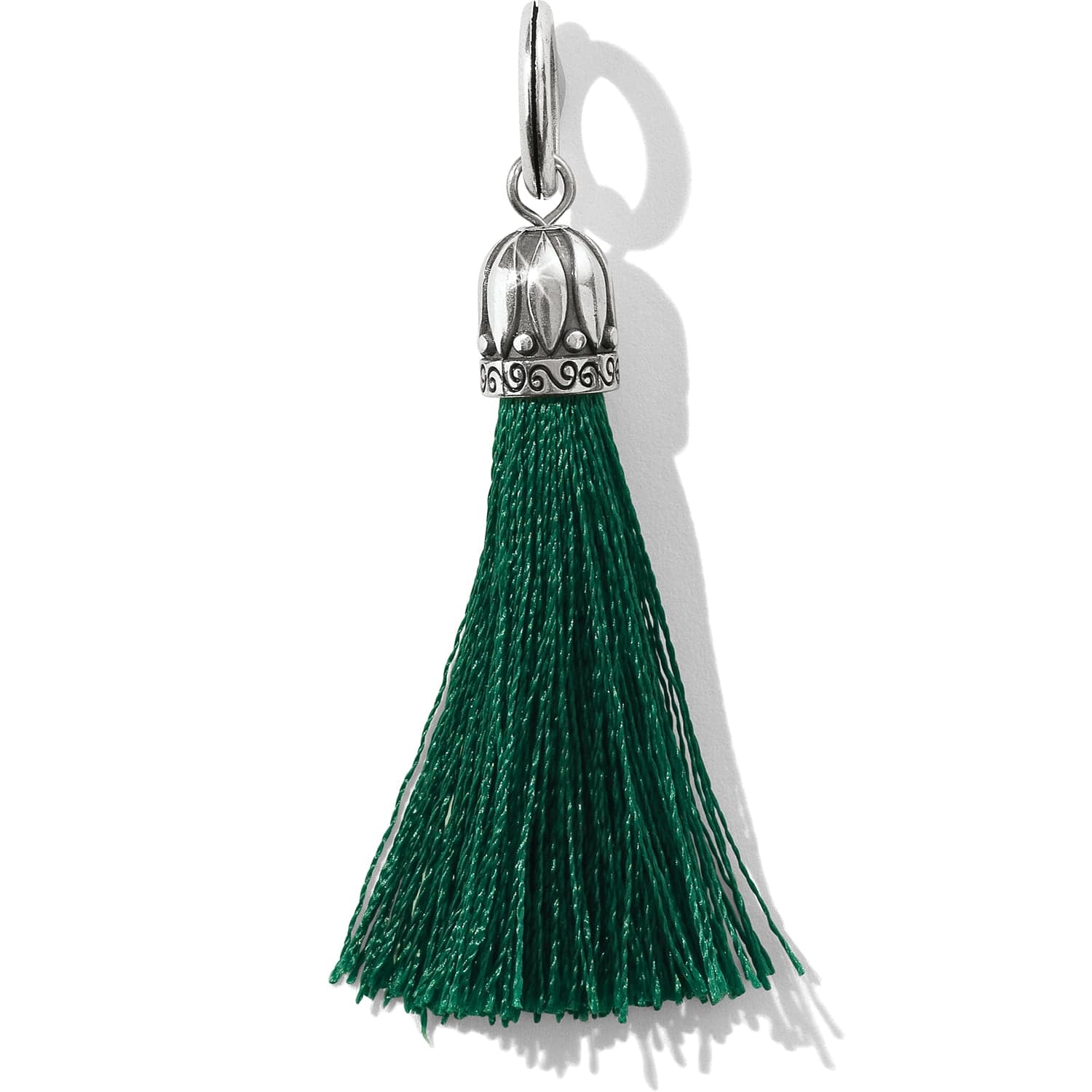 Brighton tassel charm with green threads and silver-plated decorative cap with scrollwork detail on a white background