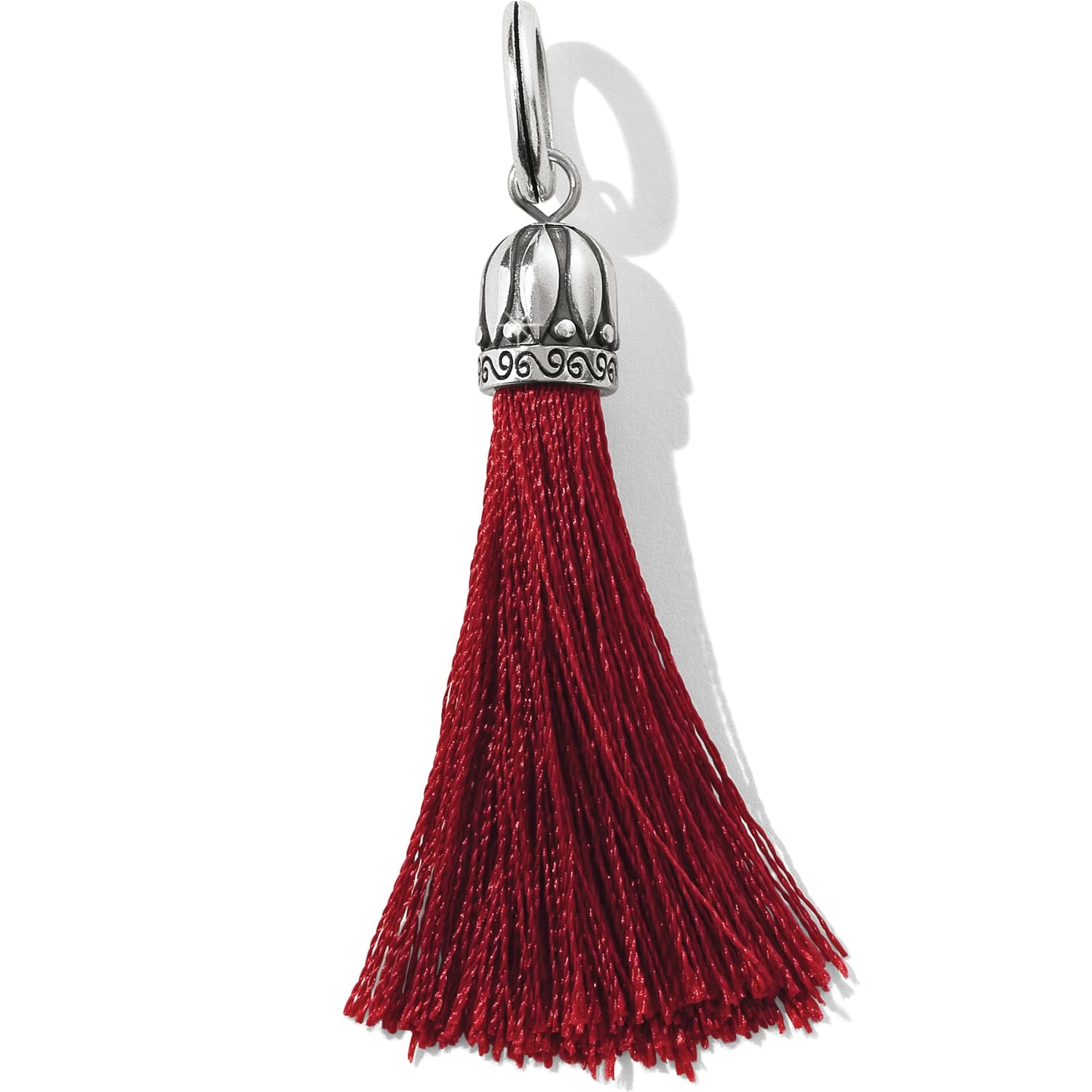 Brighton tassel charm with red fringe and silver-plated ornate cap with scroll detailing on a white background