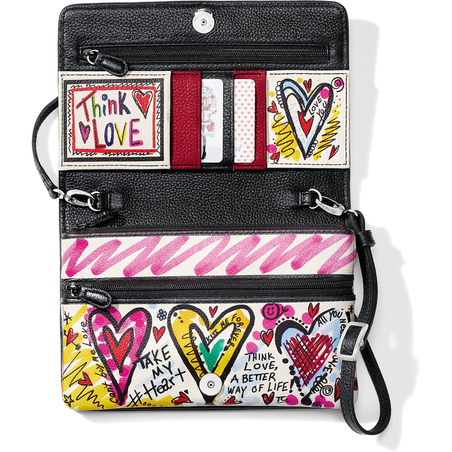 Brighton wallet shown open with heart graphic print, card slots, zip pockets, and wristlet strap on a white background
