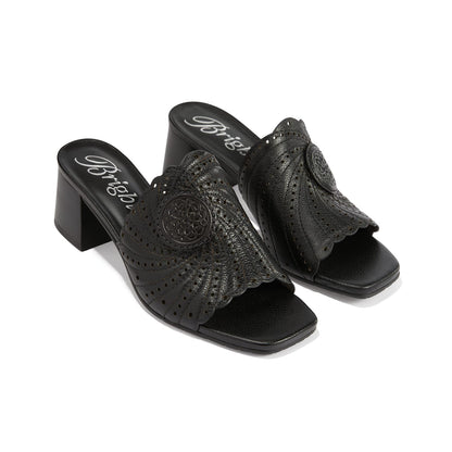Brighton black leather block heel slide sandals with perforated scalloped detail and medallion accent on a white background