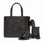 Brighton leather handbag with swirl cutout pattern and medallion, styled with matching heeled sandals on white background