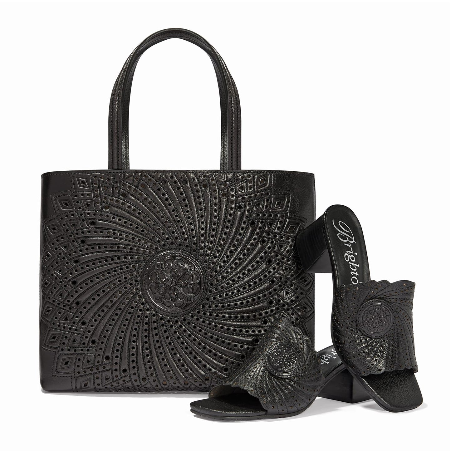 Brighton leather handbag with swirl cutout pattern and medallion, styled with matching heeled sandals on white background