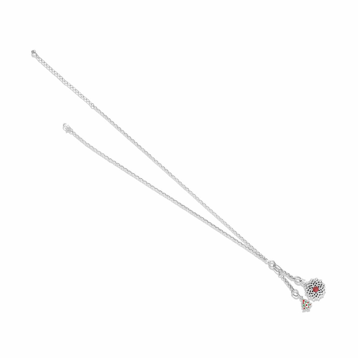 Brighton charm necklace with silver-tone chain, heart charm with red crystal, and Christmas tree charm on a white background