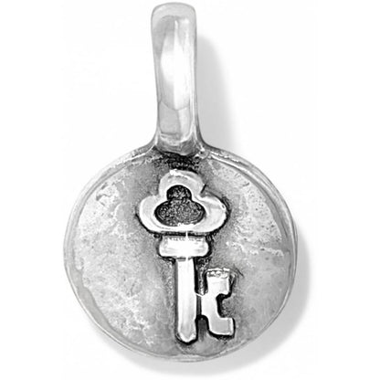 Brighton charm with silver-plated round medallion featuring embossed skeleton key design and top loop on a white background