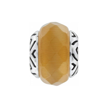 Brighton charm bead with faceted amber stone center and silver-plated chevron patterned sides on a white background
