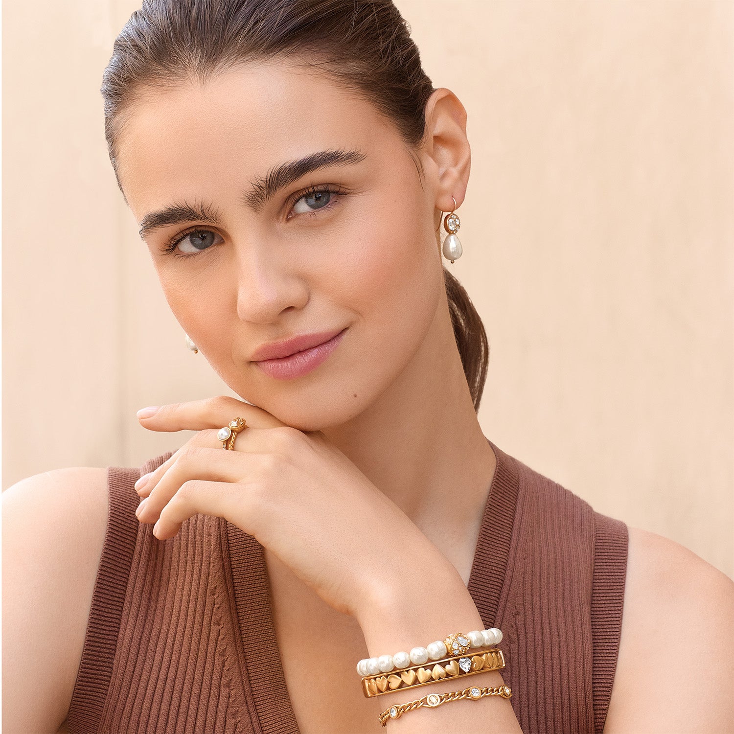 Model wearing Brighton gold-plated drop earrings with glass pearl and coordinating Brighton accessories including pearl bracelets and rings