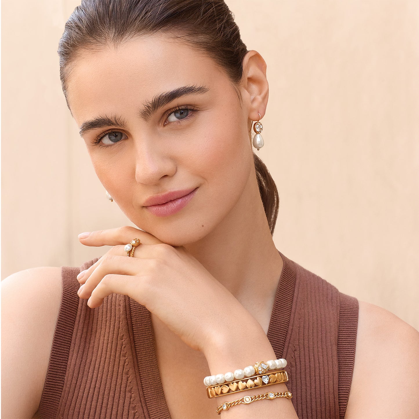 Model wearing Brighton gold-plated drop earrings with glass pearl and coordinating Brighton accessories including pearl bracelets and rings