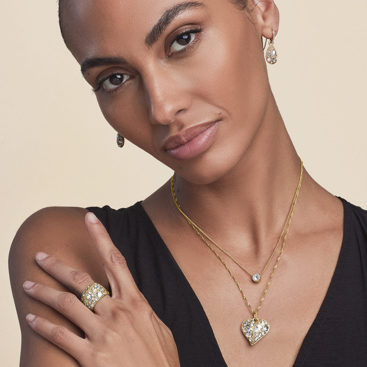 Model wearing a Brighton gold-plated crystal heart pendant necklace with coordinating Brighton accessories including earrings and ring