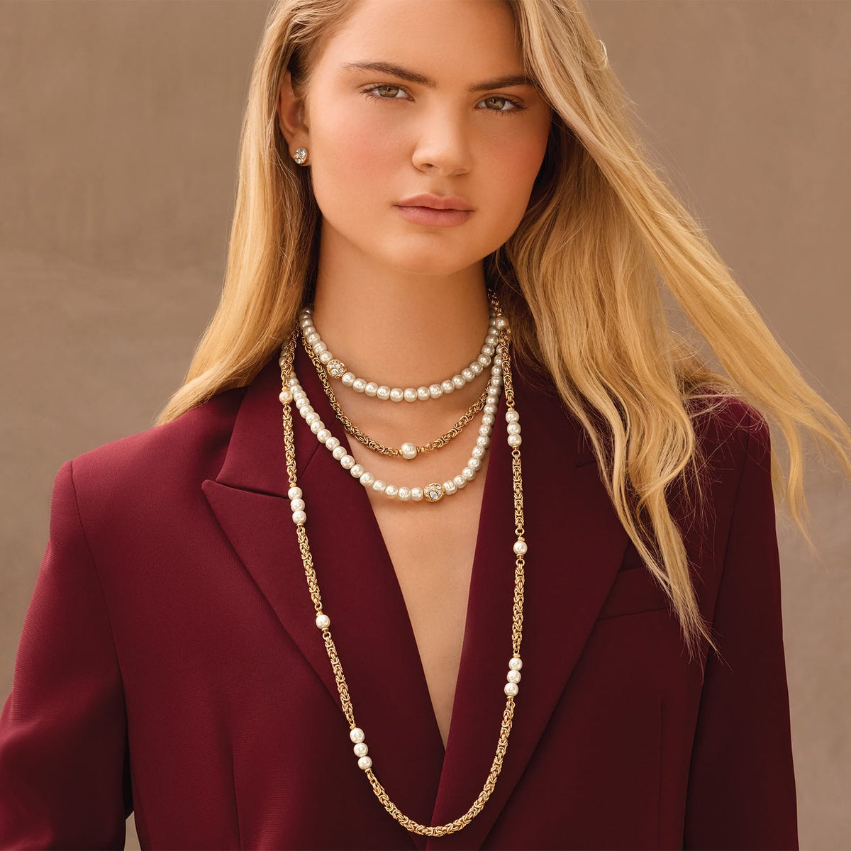 Model wearing layered Brighton pearl necklaces with gold-plated Byzantine chain accents and crystal-set beaded stations