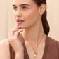 Model wearing Brighton gold-plated hoop earrings with crystals and coordinating Brighton necklaces with baroque pearl pendant