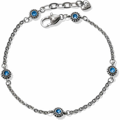 Brighton silver-plated chain bracelet with blue crystal floral stations, lobster clasp, and heart charm on a white background
