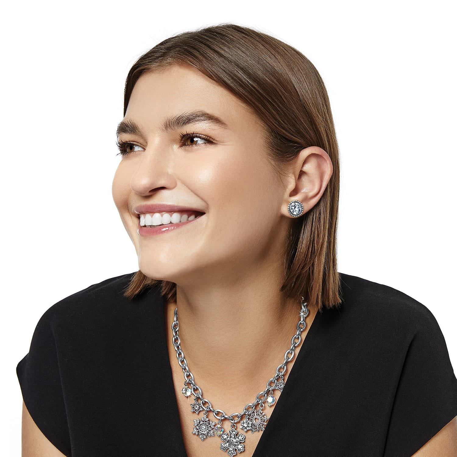 Model wearing Brighton silver-plated crystal stud earrings paired with a silver-plated snowflake charm necklace with crystals