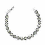 Brighton bracelet with green crystals set in beaded silver-plated links and hinged clasp on a white background