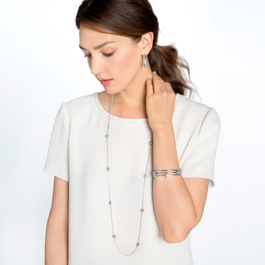 Model wearing a Brighton long silver-plated station necklace with crystal accents and coordinating Brighton accessories