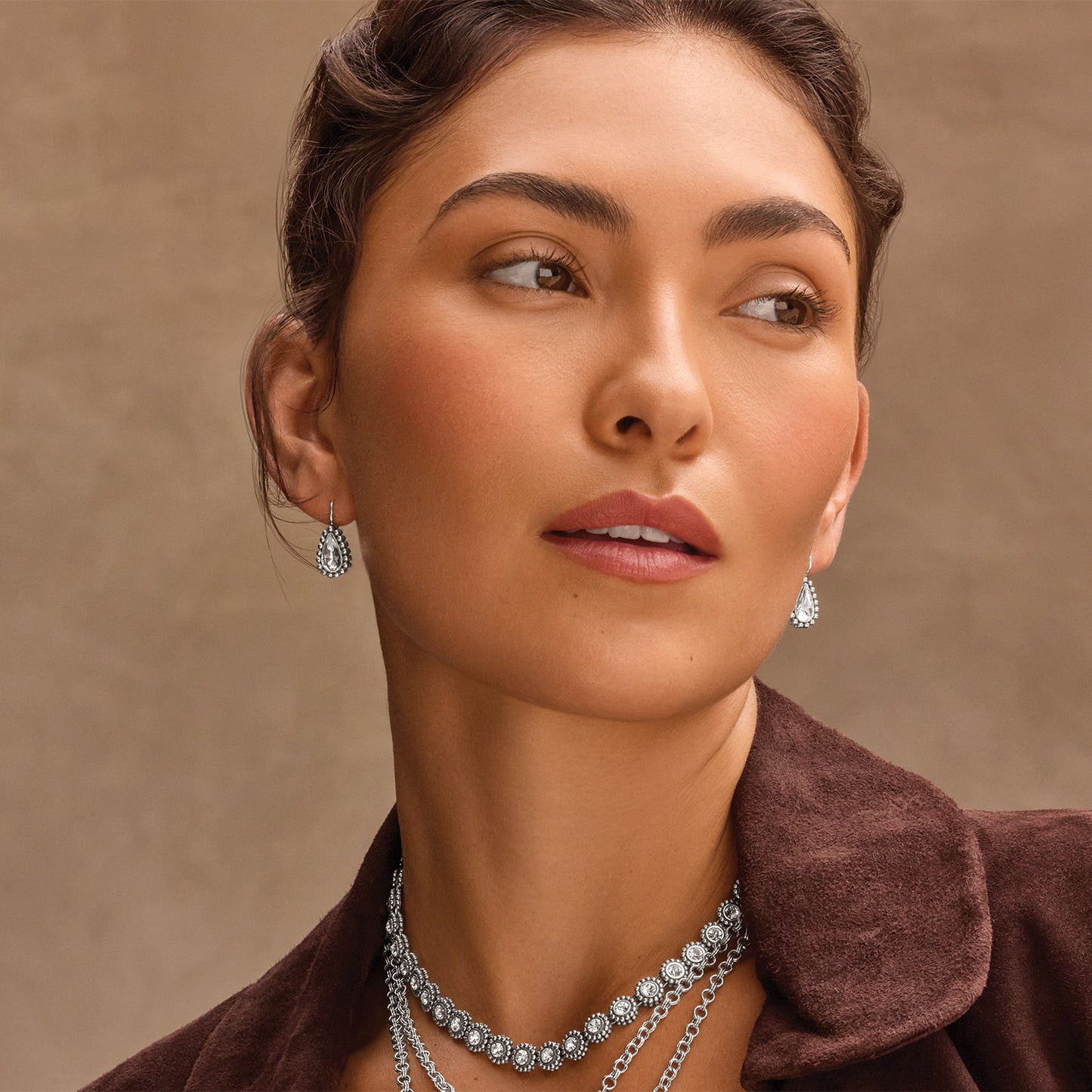 Model wearing Brighton silver-plated teardrop earrings with crystals and coordinating Brighton crystal-accented layered chain necklaces
