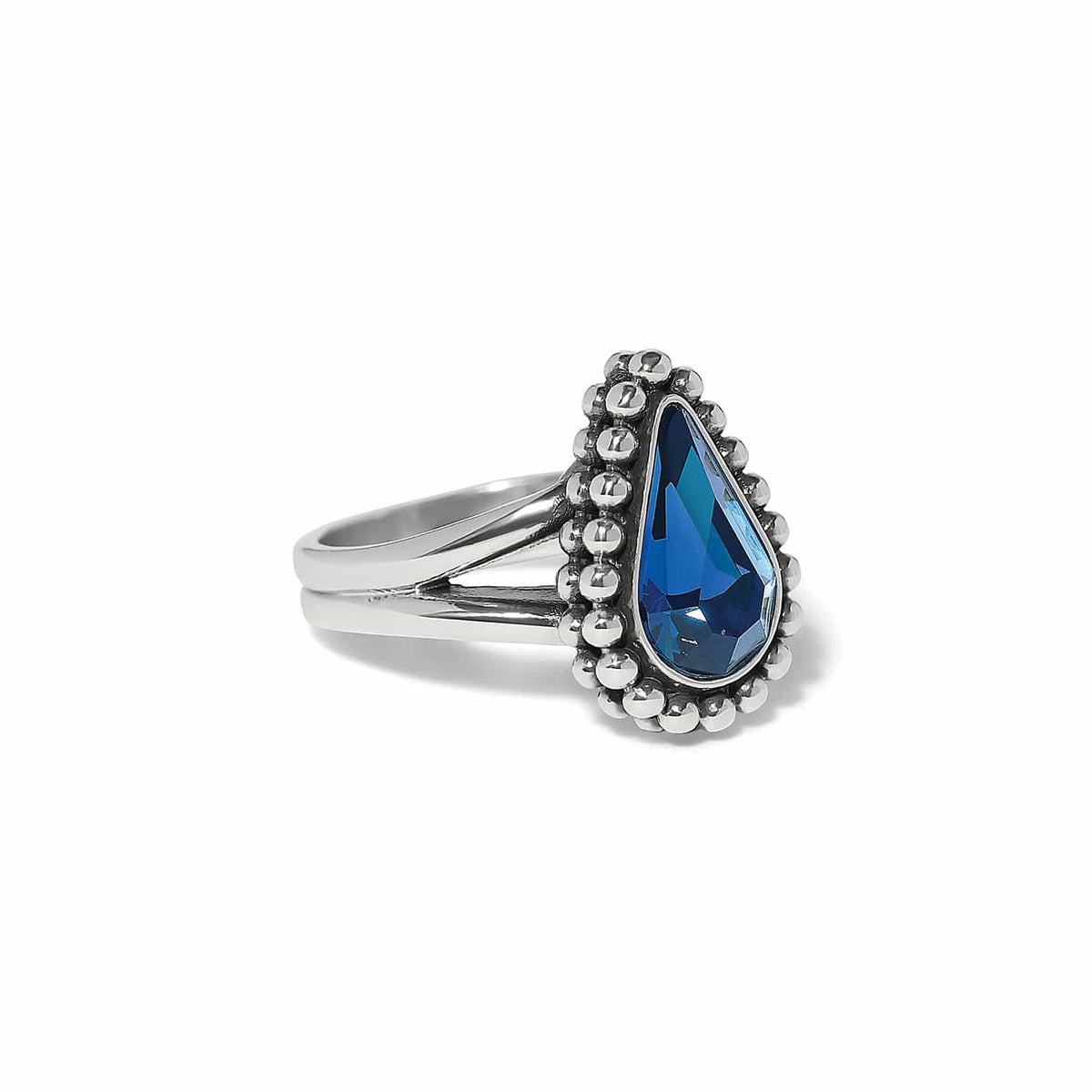 Brighton ring with teardrop blue crystal and silver-plated beaded halo on a split band on a white background