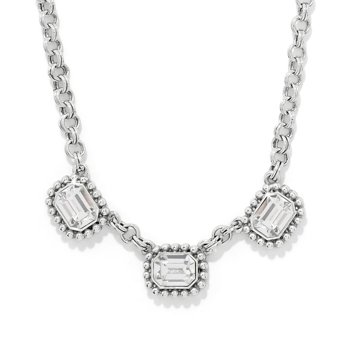 Brighton necklace with three emerald-cut crystals in silver-plated beaded frames on a rolo chain on a white background