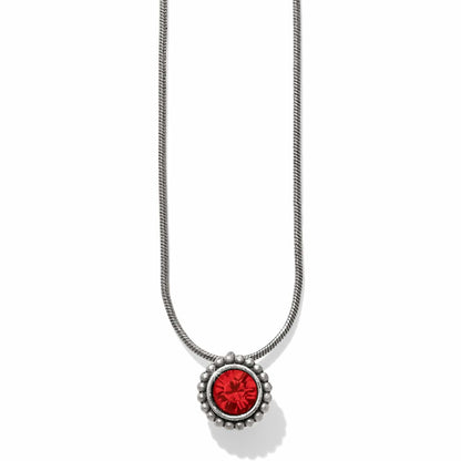 Brighton pendant necklace with red crystal center and beaded silver-plated frame on snake chain on a white background