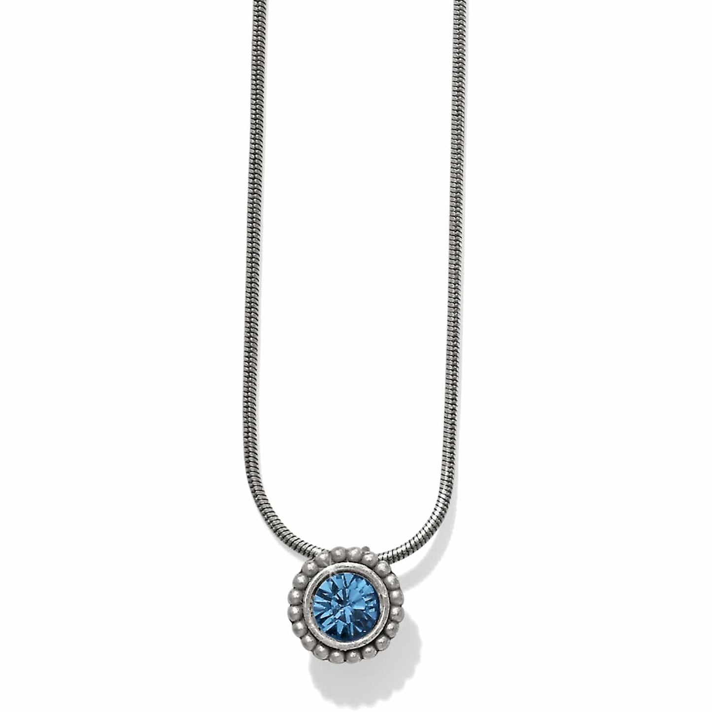 Brighton pendant necklace with blue crystal centerpiece, beaded silver-plated frame, and snake chain on a white background