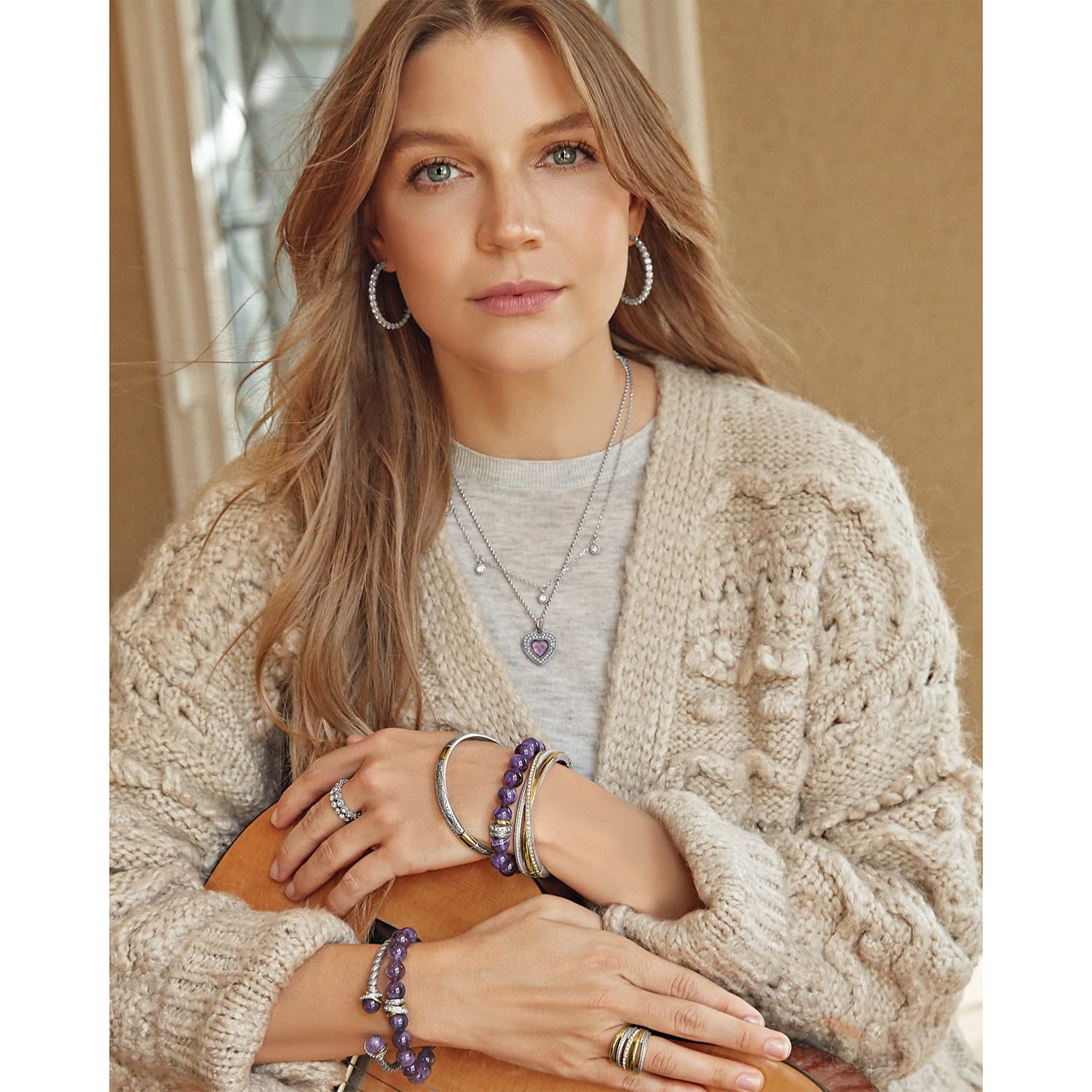 Model wearing a Brighton silver-plated layered necklace with crystal accents and purple heart pendant, with coordinating Brighton accessories