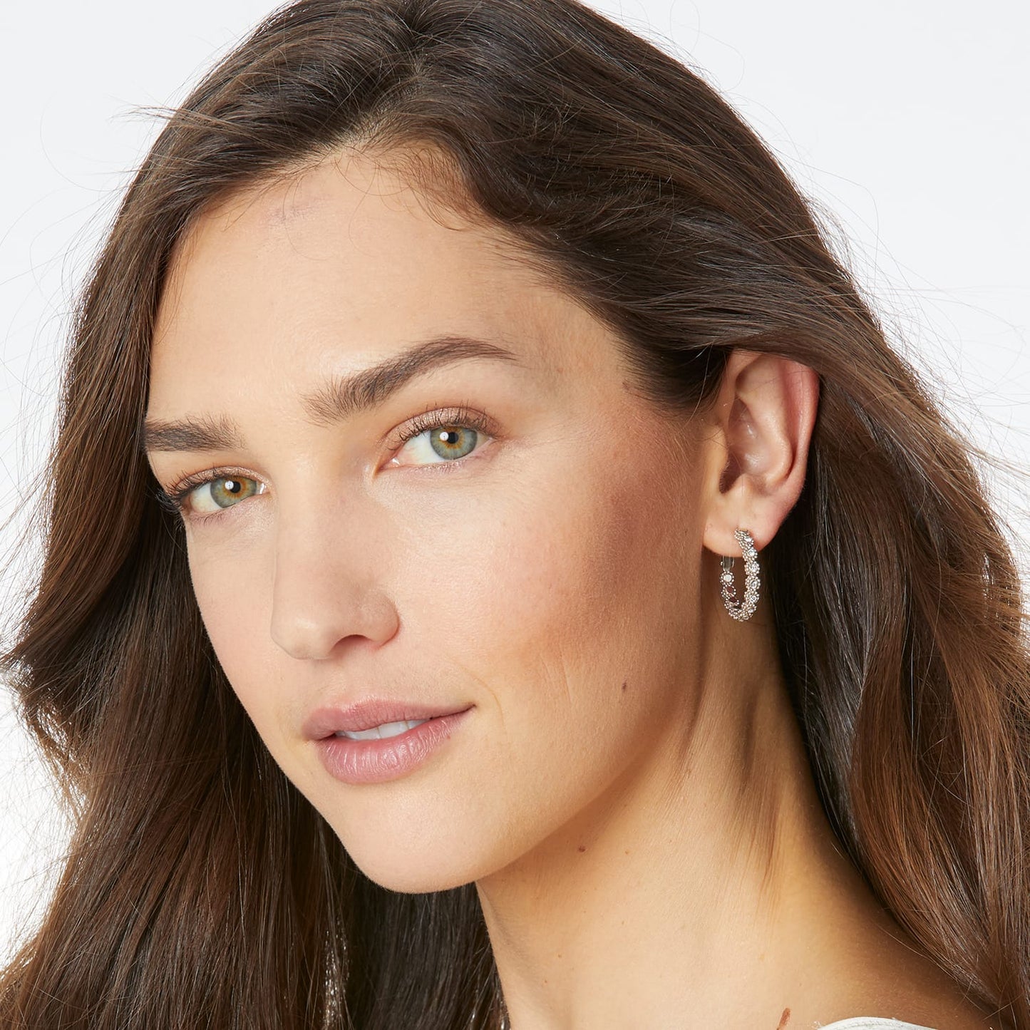 Model wearing Brighton silver-plated hoop earrings with fine quality crystals in a twisted design