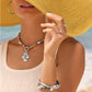 Model wearing a Brighton beaded necklace with silver swirl pendant and coordinating Brighton accessories with mixed gemstones