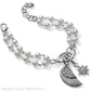 Brighton beaded bracelet with double strand of pearls, silver-plated wing charm, and crystal star on a white background
