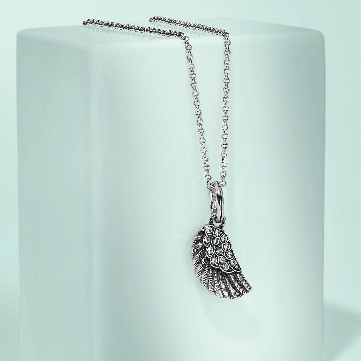 Brighton pendant necklace with silver-tone wing charm and crystal accents on a pale mint background