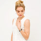 Model wearing a Brighton silver-plated bracelet with black enamel bands and crystal accents, paired with silver hoop earrings