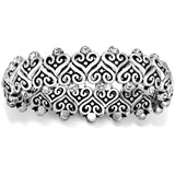 An Alcazar Heart Stretch silver bracelet with intricate scroll patterns and embedded crystals rests against a white background.
