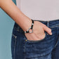Model wearing Heritage Heart Bracelet with hand in pocket
