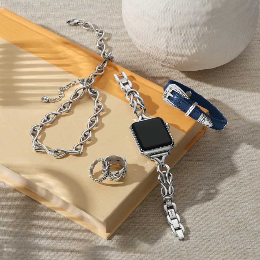 Interlok Harmony Apple Watch Band with matching rings and necklace shown on a book